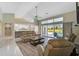Open-concept living room with wood floors, neutral tones, and sliding glass doors that lead to the pool area at 447 Rotonda Cir, Rotonda West, FL 33947