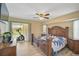 View of the main bedroom which features a ceiling fan, wood floors, and a view to the patio at 447 Rotonda Cir, Rotonda West, FL 33947