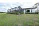 Manicured backyard features lush green grass and trimmed hedges, complemented by the home's architecture and screened-in lanai at 4532 Chase Oaks Dr, Sarasota, FL 34241
