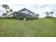 Manicured backyard features lush green grass and trimmed hedges, complemented by the home's architecture and screened-in lanai at 4532 Chase Oaks Dr, Sarasota, FL 34241