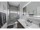 Modern bathroom features tile shower, stone floor, and bright vanity lighting at 4532 Chase Oaks Dr, Sarasota, FL 34241
