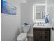 Charming half bathroom with stylish mirror lighting, dark wood cabinet, and turtle artwork at 4532 Chase Oaks Dr, Sarasota, FL 34241