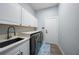 Laundry room featuring sink, white cabinets, and front load washer dryer at 4532 Chase Oaks Dr, Sarasota, FL 34241