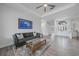 Well-lit living room with hardwood floors, a ceiling fan, and an elegant entryway with arched transom window at 4532 Chase Oaks Dr, Sarasota, FL 34241