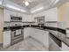 Well-lit kitchen featuring white cabinets, stainless steel appliances, and granite countertops at 455 Rubens E Dr, Nokomis, FL 34275