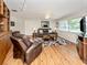 Inviting living room with a comfortable leather sofa, arm chair, and hardwood floors at 455 Rubens E Dr, Nokomis, FL 34275