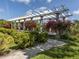 Elegant outdoor pergola surrounded by lush landscaping and blooming flowers at 455 Rubens E Dr, Nokomis, FL 34275