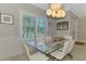 Dining room with a modern light fixture, large windows, and ample seating for entertaining guests at 4624 Caribou Ave, North Port, FL 34287