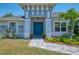Home featuring a stylish blue front door and beautiful landscaping creating a welcoming entryway at 4624 Caribou Ave, North Port, FL 34287