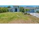 A home with a well-kept lawn, fresh landscaping, and a walkway leading to a bold blue front door at 4624 Caribou Ave, North Port, FL 34287