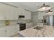Elegant kitchen with white cabinets, marble countertops, stainless steel appliances, and modern lighting at 4624 Caribou Ave, North Port, FL 34287