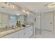 Well-lit main bathroom with double sinks, granite countertops, a large mirror, and a walk-in shower at 4624 Caribou Ave, North Port, FL 34287