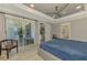 Bright main bedroom boasts a ceiling fan, tray ceilings, and sliding glass doors to the outdoor living area at 4624 Caribou Ave, North Port, FL 34287