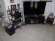 Cozy living room showcasing a large TV, display shelves, and decorative items at 475 Whippoorwill Dr, Venice, FL 34293