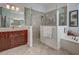 Bright bathroom featuring a walk-in shower, vanity and soaking tub at 515 Sawgrass Bridge Rd, Venice, FL 34292