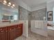 Bright bathroom featuring a walk-in shower, vanity and soaking tub at 515 Sawgrass Bridge Rd, Venice, FL 34292