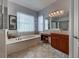 Bathroom with soaking tub, vanity and tile flooring at 515 Sawgrass Bridge Rd, Venice, FL 34292