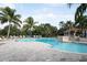 Large community pool with palm trees and ample lounge seating on a sunny day at 515 Sawgrass Bridge Rd, Venice, FL 34292