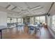 Spacious community room with tables, chairs, bookshelves, and plenty of natural light at 515 Sawgrass Bridge Rd, Venice, FL 34292