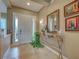 Elegant foyer with a decorative mirror, marble-top table, and tiled flooring at 515 Sawgrass Bridge Rd, Venice, FL 34292