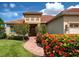 Charming home featuring a brick walkway leading to the front door with beautiful landscaping and a clay tile roof at 515 Sawgrass Bridge Rd, Venice, FL 34292