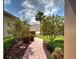Landscaped front yard with a curved brick walkway, trees, and a well-manicured lawn at 515 Sawgrass Bridge Rd, Venice, FL 34292