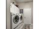 Modern laundry area with high-efficiency washer and dryer, bright white cabinets, and white walls at 515 Sawgrass Bridge Rd, Venice, FL 34292
