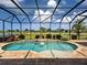 Screened-in pool area with a waterfall feature and beautiful golf course views at 515 Sawgrass Bridge Rd, Venice, FL 34292