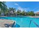 Community pool with ample lounge chairs and tropical landscaping provides a resort-like experience at 515 Sawgrass Bridge Rd, Venice, FL 34292