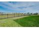 The backyard offers a black metal fence with a view of the tranquil pond with a fountain at 5222 Granite Dust Pl, Palmetto, FL 34221