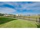 Lush backyard with serene water view, secure black metal fence and open sky at 5222 Granite Dust Pl, Palmetto, FL 34221