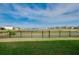 A well-kept lawn with a black metal fence that looks out over a pond and a distant fountain feature at 5222 Granite Dust Pl, Palmetto, FL 34221
