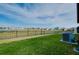 Well-manicured lawn leading to a black metal fence with a serene pond and neighboring houses visible at 5222 Granite Dust Pl, Palmetto, FL 34221