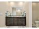 Bathroom features a dual sink vanity with granite counters, cabinets and large framed mirror at 5222 Granite Dust Pl, Palmetto, FL 34221