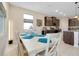 Open-concept dining area with a white table, chairs, and views of the kitchen at 5222 Granite Dust Pl, Palmetto, FL 34221