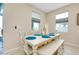 Bright dining area features white table and bench with blue placemats under dual windows at 5222 Granite Dust Pl, Palmetto, FL 34221