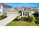 Beautiful one-story home featuring a two-car garage, stone veneer, and manicured landscaping near a lake at 5222 Granite Dust Pl, Palmetto, FL 34221