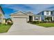 Attractive one-story home with a two-car garage and well-maintained landscaping under a clear blue sky at 5222 Granite Dust Pl, Palmetto, FL 34221