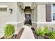 Covered entryway with stone accents, leading to a dark wood front door and stylish exterior lighting at 5222 Granite Dust Pl, Palmetto, FL 34221