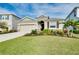 Charming single-story home with a well-manicured lawn, lush landscaping, and a two-car garage at 5222 Granite Dust Pl, Palmetto, FL 34221