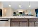 Granite kitchen island with stainless sink and view into living area with modern decor at 5222 Granite Dust Pl, Palmetto, FL 34221