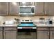 Close-up of kitchen featuring stainless steel appliances, granite countertops, and dark wood cabinets at 5222 Granite Dust Pl, Palmetto, FL 34221