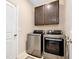 Modern laundry area featuring a new washer and dryer with overhead cabinet at 5222 Granite Dust Pl, Palmetto, FL 34221