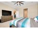 Large main bedroom with large TV, tray ceilings, and view of other rooms at 5222 Granite Dust Pl, Palmetto, FL 34221