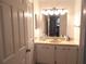 Bathroom vanity with ample lighting, built in sink, and an open view of bedroom at 542 Walnut Cir, Venice, FL 34285