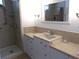Bathroom with a step-in shower, vanity with cream countertop, mirror, and updated fixtures at 542 Walnut Cir, Venice, FL 34285