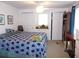 Bedroom with blue patterned quilt, built in closet, drawers, and bookshelf at 542 Walnut Cir, Venice, FL 34285