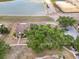 An aerial view of the townhomes showcasing the mature trees, landscaping, and lakeside location at 5559 Brassy Loop, North Port, FL 34287