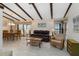 Comfortable living room with wood-beamed ceilings, tile floors, and access to a screened-in patio at 5559 Brassy Loop, North Port, FL 34287