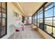 Cozy sunroom with tiled floor, ceiling fan and walls of windows overlooking the water at 5559 Brassy Loop, North Port, FL 34287